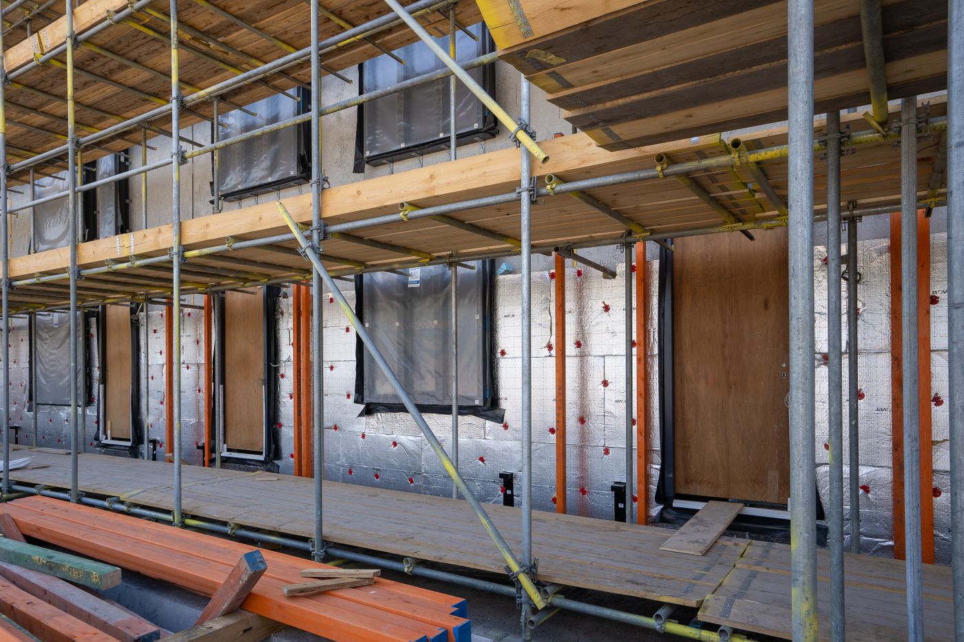 Energetische Sanierung: eingerüstetes Wohnhaus mit sichtbaren Dämmplatten